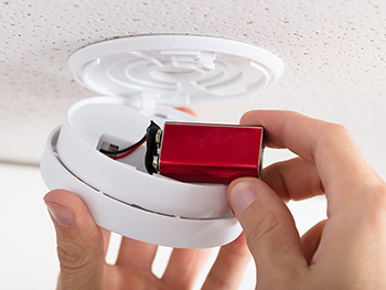 Changing the battery in a smoke detector.