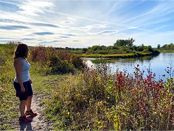 Woman walking on trail beside lake