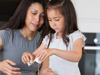 Mother and daughter cracking an egg together