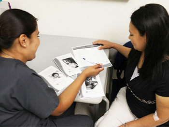 Two women looking at breastfeeding resources.