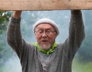 elderly gentleman leaning on a post