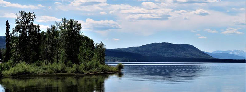 Lake in the summer with mountains in the background.