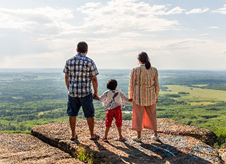 Family of three looking out from a view point in Dawson Creek.