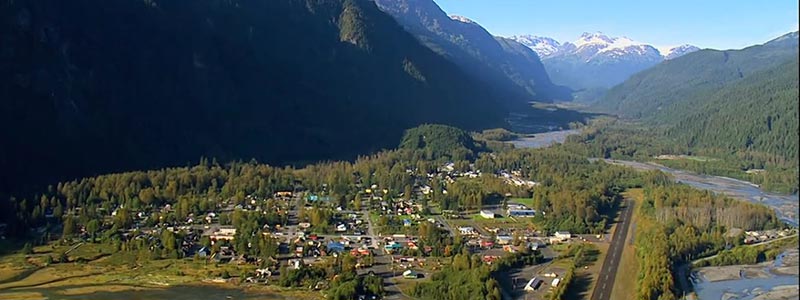 Aerial view of Stewart with snow capped mountains in the background.