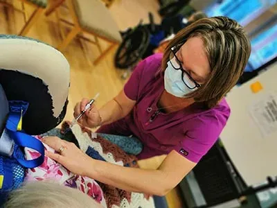 Vaccination being given by a medical professional wearing a protective surgical mask
